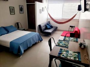 a bedroom with a bed and a table and a chair at Apto Nacaela-Bocagrande cerca a la playa in Cartagena de Indias