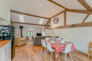 a kitchen and living room with a table and chairs at The Hayloft in Mold