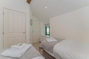 a bedroom with two beds with towels on them at The Hayloft in Mold +11 photos