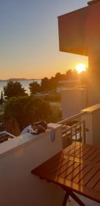 a sunset on the balcony of a house with a table at Seaview holiday house Mali Rog in Zadar