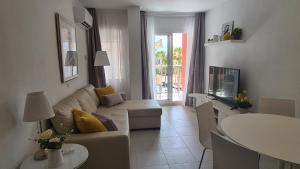 een woonkamer met een bank en een tafel bij Benalmadena JUPITER - Delux 1Bedroom Apartment in Benalmádena