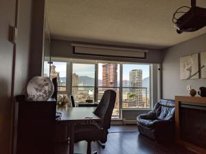 a living room with a table and a large window at Vancouver Downtown Accommodation in Vancouver