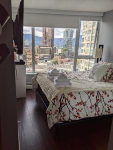 a bedroom with a bed and a large window at Vancouver Downtown Accommodation in Vancouver