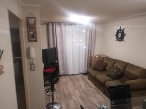 Una sala de estar con un sofá y un televisor. en Departamento Hospedaje Rancagua Centro, en Rancagua