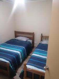 蘭卡瓜的住宿－Departamento Hospedaje Rancagua Centro，一间卧室设有两张床,一扇门打开