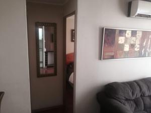 sala de estar con sofá y espejo en Departamento Hospedaje Rancagua Centro, en Rancagua