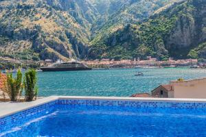 a swimming pool with a view of the water and mountains at Apartments Dončić in Kotor
