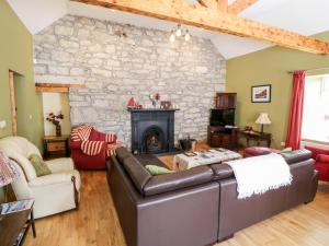 a living room with a couch and a stone fireplace at Prague House in Lettermore