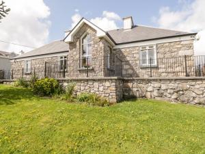 a stone house with a fence and a yard at Prague House in Lettermore