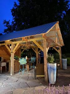 a wooden gazebo with two chairs and a table at BEACH HAVEN Dog friendly farmette Great for 2 couples in Berlin