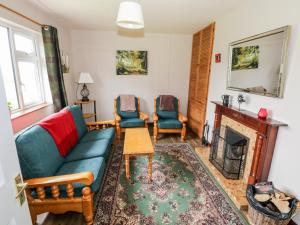 - un salon avec un canapé, des chaises et une cheminée dans l'établissement Roundstone Bay View, à Roundstone