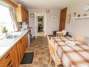 a kitchen and dining room with a table and a sink at Roundstone Bay View in Roundstone