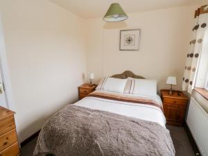 a small bedroom with a bed and two night stands at Roundstone Bay View in Roundstone
