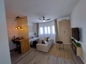 1 dormitorio con cama, sofá y escritorio en Arena Negra en Tarajalejo