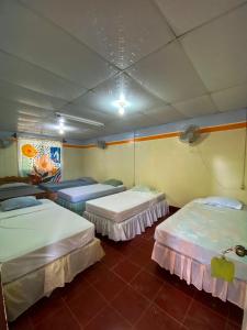 a room with three beds in a room at Hostal tortuga viajera in Moyogalpa