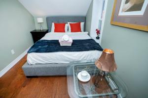 a bedroom with a bed with red pillows and a glass table at Cute 2-story, 2-bdrm Loft, Mins to Beach and Lake in Cobourg