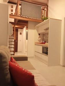 a living room with a couch and a kitchen at Solar Flats - WooD - Pipa RN in Pipa