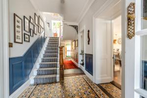 a hallway with blue and white walls and a blue staircase at Rhodewood Lodge in Saundersfoot