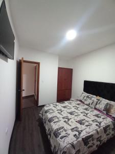 a bedroom with a bed and a flat screen tv at Hostería La Chorrera in Quito