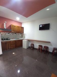 a kitchen with a counter and stools in a room at Hostería La Chorrera in Quito