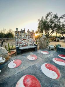 a garden with red and white painted rocks and a bench at Estancia Los Amigos Valle de Guadalupe in Valle de Guadalupe