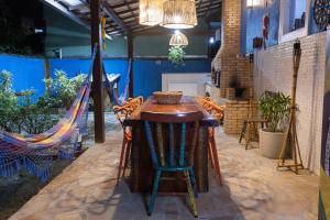 a room with a table and chairs and a hammock at Casa azul Ilha Grande in Abraão