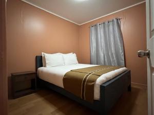a small bedroom with a bed with a window at Cabañas Caur in San Pedro de Atacama