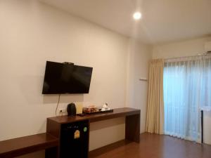 a living room with a flat screen tv on the wall at Blue Orchid Beach Krabi - SHA Certified in Ao Nam Mao