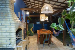 a dining room with a table and a brick oven at Casa azul Ilha Grande in Abraão