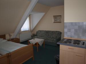 a room with a bed and a couch and a kitchen at Hotel Societät in Emmerich