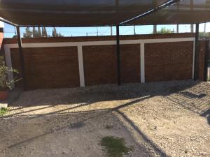 a brick wall with a canopy in a yard at Ciudad de las Colinas in Victoria