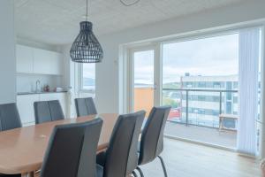 a dining room with a table and chairs and a large window at New / Stunning Sea View / Light / 3 BR in Tórshavn