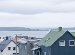 a row of houses with the ocean in the background at New / Stunning Sea View / Light / 3 BR in Tórshavn
