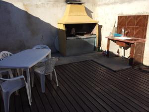 un patio al aire libre con mesa y horno en Ciudad de las Colinas en Victoria