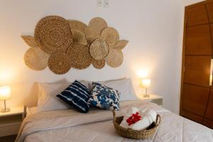 a bed with pillows and a basket on it at Casa azul Ilha Grande in Abraão