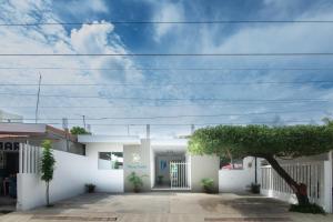 een wit huis met een boom ervoor bij Apartaestudio Playa Linda 101 in Coveñas