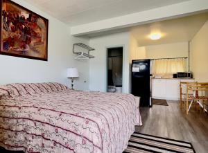 a bedroom with a large bed and a kitchen at Airport Inn in Quesnel