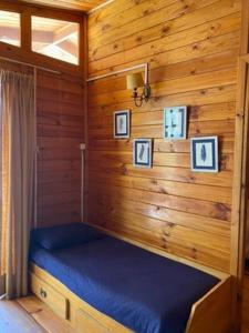a room with a blue bed in a cabin at Rancho el Chilcal Cabañas con vista al rio in San Alfonso