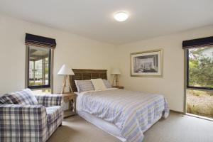 a bedroom with a bed and a couch and windows at Purfect Purnell in Anglesea