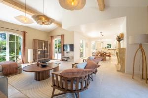 a living room with a couch and a table at SERRENDY Villa with infinity swimming pool in Roquefort-les-Pins