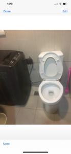 a bathroom with a white toilet and a black trash can at Princess Place at Shell Residences in Manila
