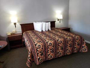 Swiss Village Inn في يوريكا سبرينغز: غرفة فندق بسرير كبير مع مخدات