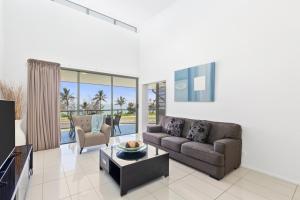 a living room with a couch and a table at Beaches on Lammermoor Apartments in Yeppoon