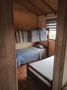 a small room with two bunk beds and a window at Cabaña Punto Punahue in Choshuenco