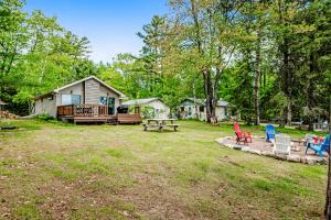 a backyard with chairs and a picnic table and a house at Whispering Pines in Harshaw