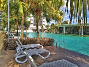 a swimming pool with two chairs next to a building at Sara Staycation in Kajang