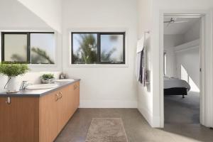 a white bathroom with two sinks and a bedroom at Cape Vista 3 in Apollo Bay