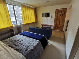 1 dormitorio con 1 cama, 1 silla y 1 ventana en Hermoso Loft, en Quito
