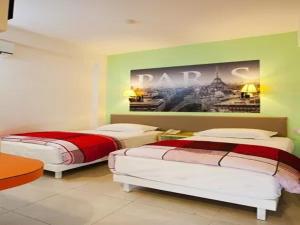 2 camas en una habitación con un cuadro en la pared en Dewarna Hotel Arifin, en Malang