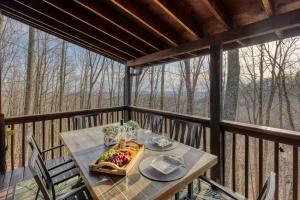 a table on a balcony with a plate of food on it at MTN Cabin Sleeps 10 - 5 Mins To Fishing & Camping in Ellijay